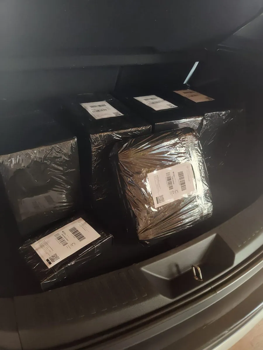 Pedidos embalados con film negro y etiquetas de envío